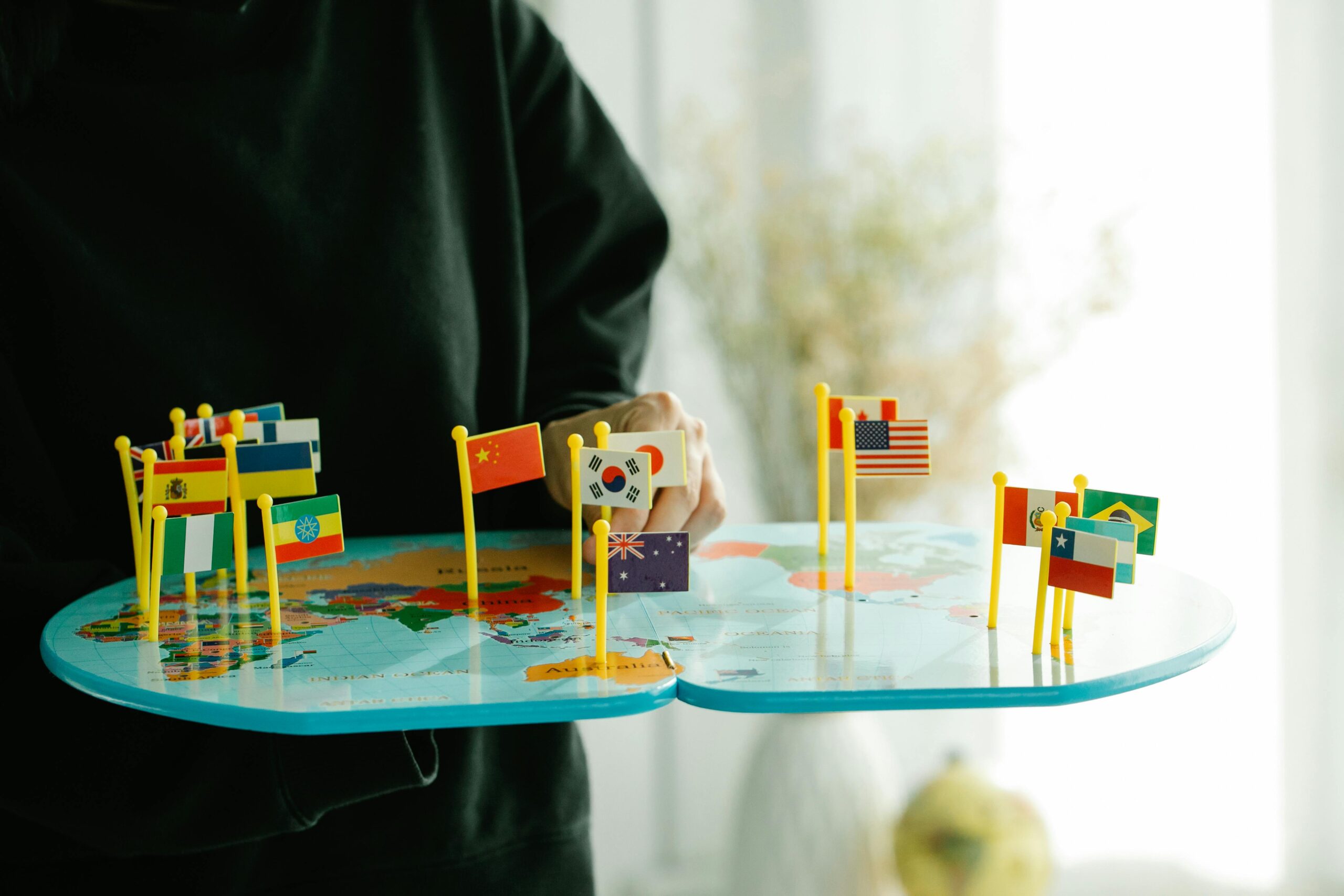 A person holding a map with flags of countries, representing global energy growth and emerging markets.
